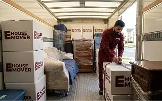 Movers arranging packed furniture and boxes inside a relocation truck in Dubai.