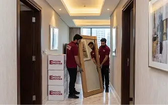 Movers carrying a mirror during apartment relocation in Dubai.