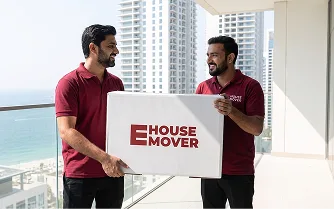 Movers carrying a packed box during apartment relocation in Dubai.