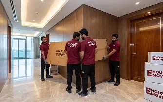Movers carrying a packed box inside a luxury Dubai apartment.