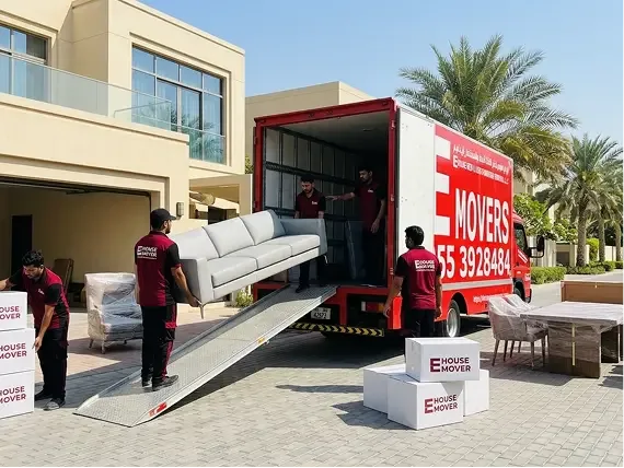 Movers loading sofa and furniture into a truck during villa relocation in Dubai.