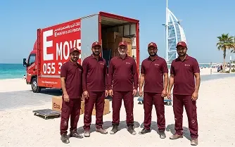 Professional Dubai movers team with moving truck near Burj Al Arab.